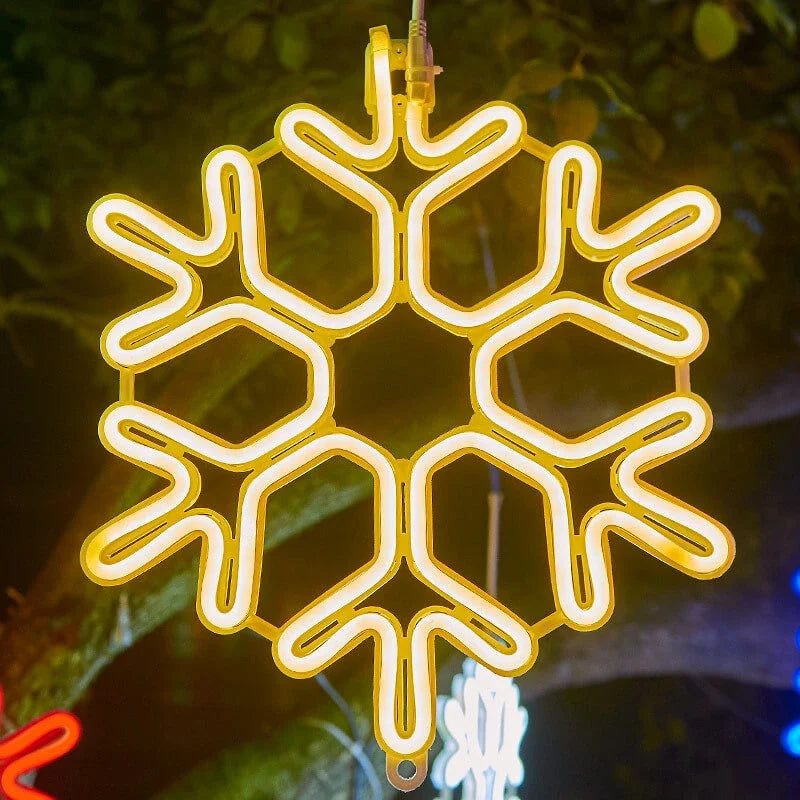 Gul neon snefnug dekoration hængende udendørs om natten, lysende klart mod en mørk baggrund. Perfekt til julebelysning og vinterudsmykning.