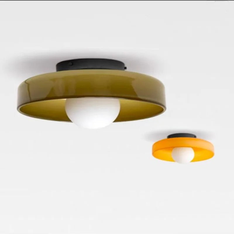 To loftlamper i moderne design, en i olivengrøn og en i orange, med runde skærme og hvid pære, monteret på hvidt loft. Ideel til stilfuld belysning.