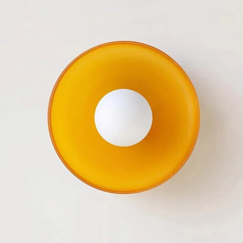Orange skål med hvid kugle i midten, minimalistisk design, moderne boligindretning, stilfuldt køkkenudstyr, skandinavisk æstetik.