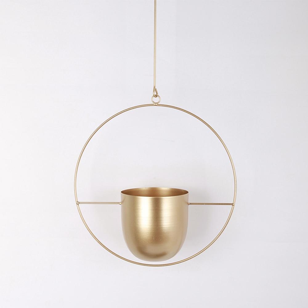 Guld hængende planteholder i minimalistisk design, cirkulær ramme, moderne indretning, stilfuld vægdekoration, skandinavisk boligindretning.
