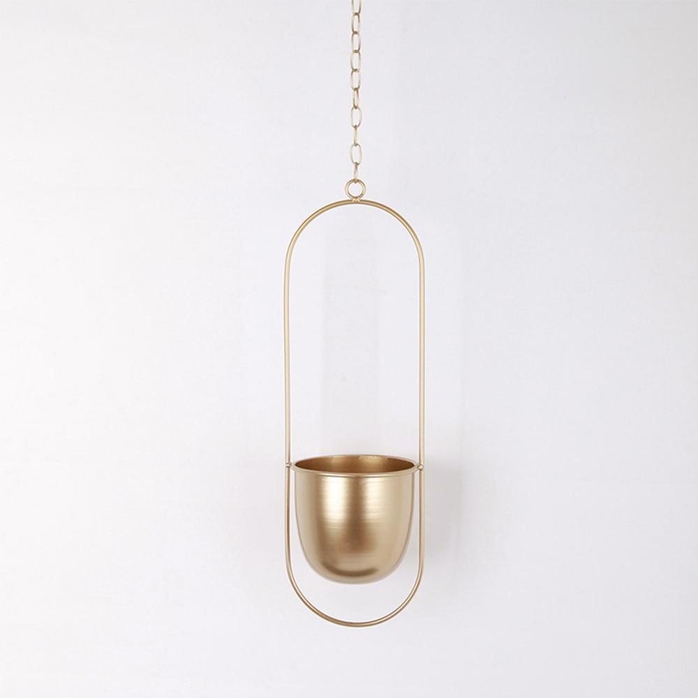 Guld hængende planteholder i minimalistisk design, ideel til moderne indretning. Perfekt til indendørs planter, skaber stilfuld atmosfære.