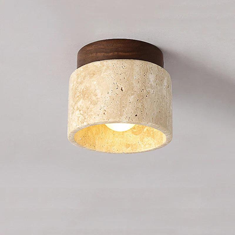 Moderne loftlampe i travertin og træ, cylinderformet design, varm belysning, ideel til stue eller køkken, stilfuld indretning.