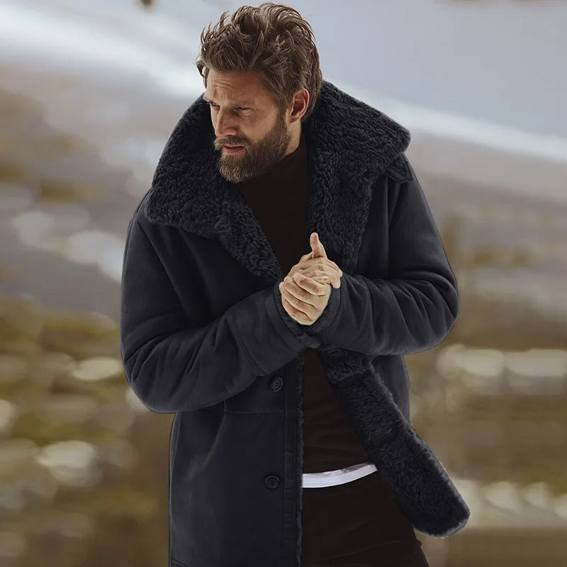 Mand i sort fåreskindsfrakke med pelskrave står udendørs om vinteren. Varm vintermode, stilfuld herrejakke, elegant overtøj.