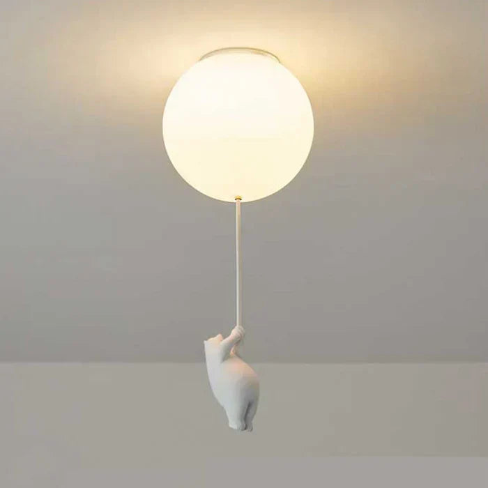 Rund loftlampe med hvid bjørnefigur, der hænger i snor. Moderne belysning, minimalistisk design, indretning, skandinavisk stil.