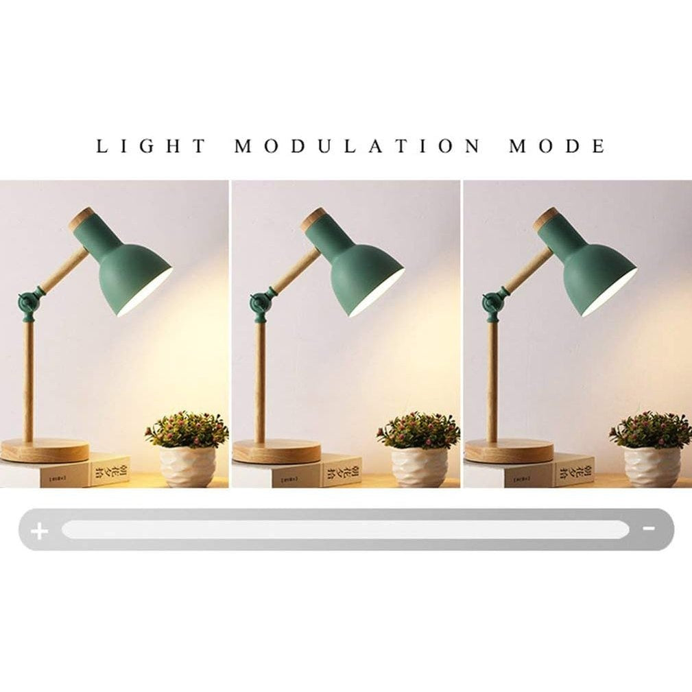 Grøn bordlampe med træbase, justerbar lysstyrke, ved siden af to små planter på træbord. Moderne design, belysning, indretning.