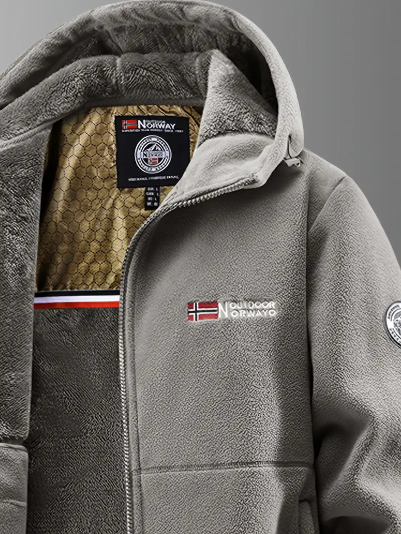 Grå softshell jakke med hætte, norsk flag og Outdoor Norway logo. Varm fleeceforing, velegnet til udendørs aktiviteter. Ideel til koldt vejr.