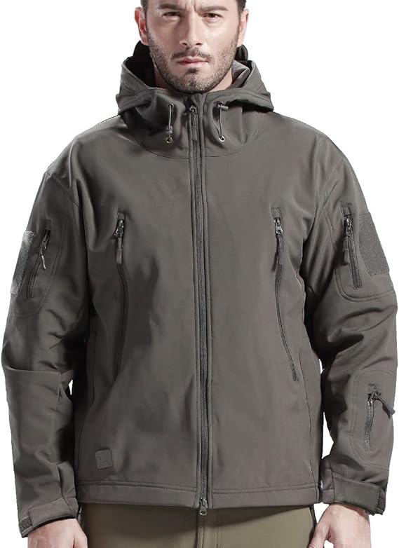 Mand iført grå softshell-jakke med hætte, lynlåslommer og justerbare manchetter. Taktisk jakke til udendørs aktiviteter og vandring.