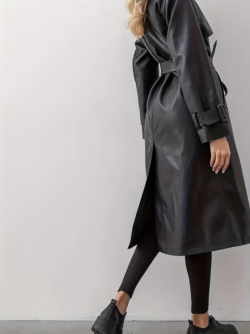Kvinde iført sort læder trenchcoat, set fra siden, med bælte og lange ærmer. Stilfuldt og moderne design, perfekt til efterårs- og vintermode.