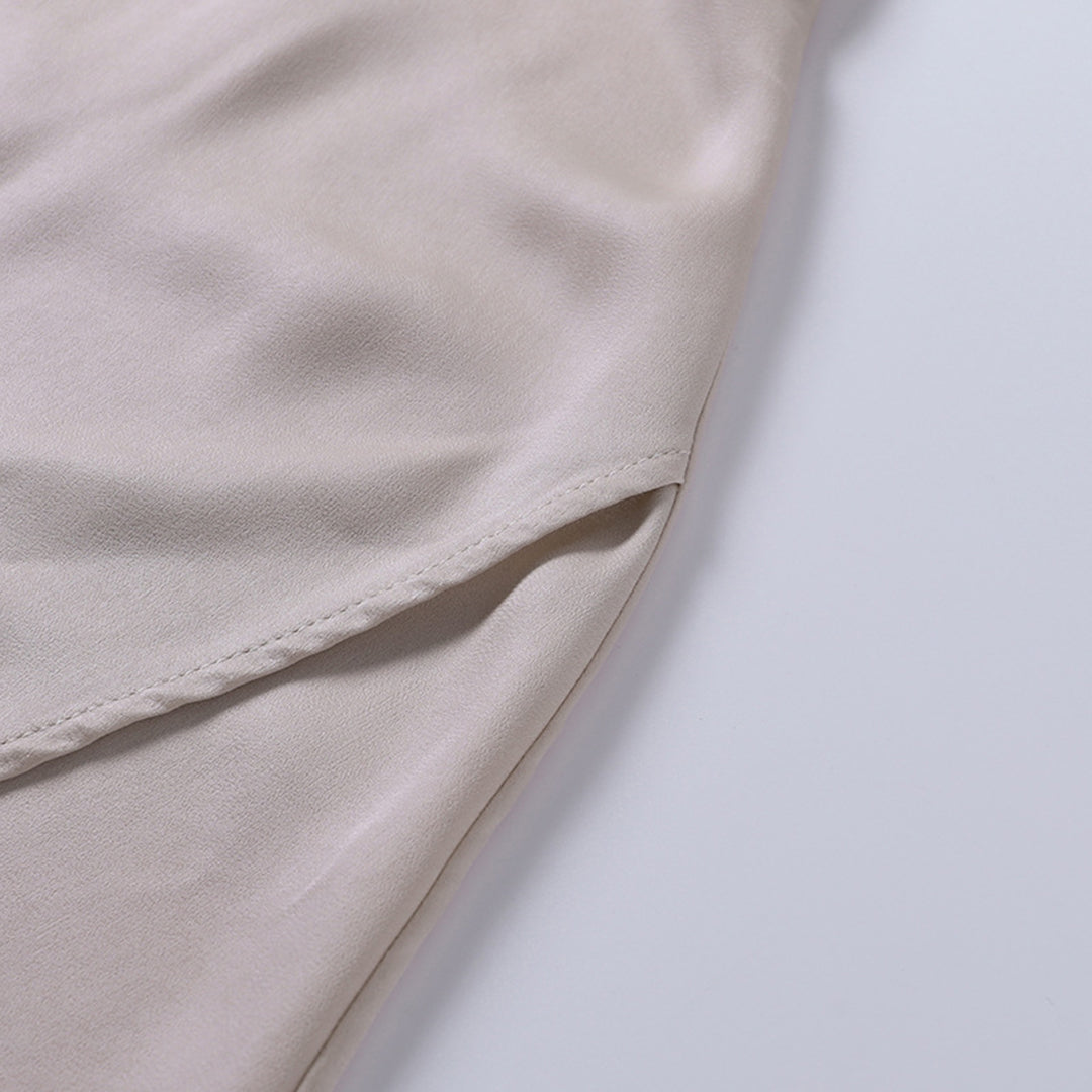 Beige silkestof med glat tekstur, nærbillede. Perfekt til mode, syning og tekstildesign. Luksuriøst materiale til kjoler og bluser.