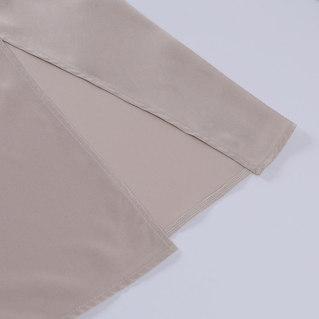 Beige satinbluse med lange ærmer, elegant design, glat tekstur, perfekt til fest eller formelle anledninger. Luksuriøst og stilfuldt tøjvalg.