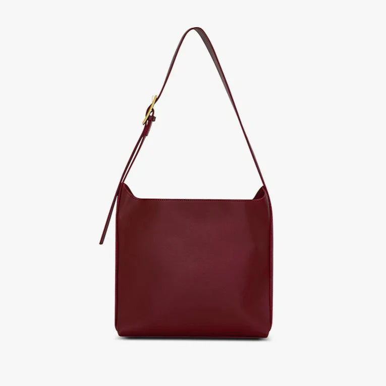 Bordeaux skuldertaske i læder med justerbar rem og minimalistisk design. Perfekt til hverdagsbrug. Elegant og stilfuld accessory.