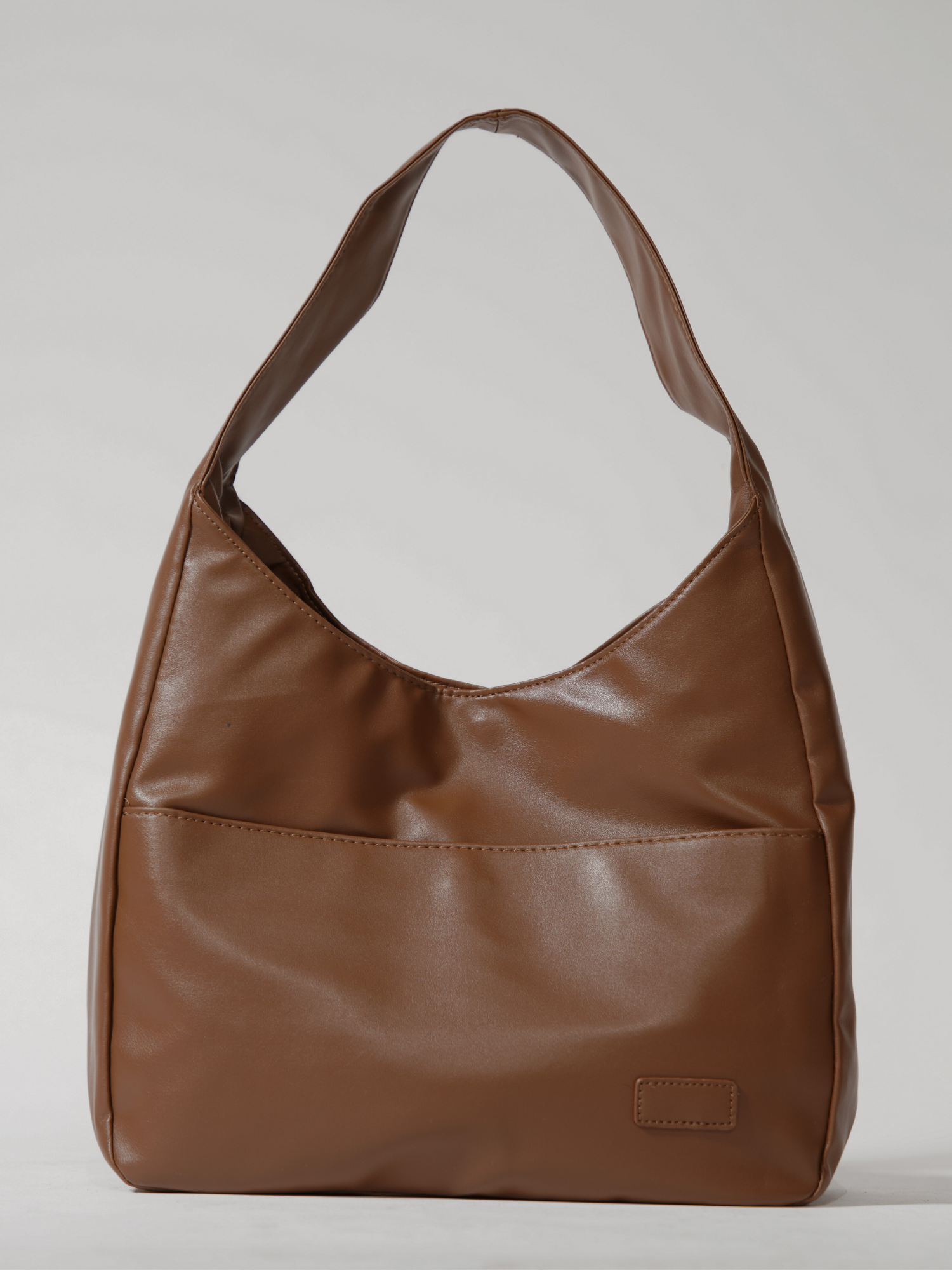 Brun læderhåndtaske med enkelt skulderrem, minimalistisk design. Perfekt til hverdagsbrug. Stilfuld og praktisk modeaccessory.