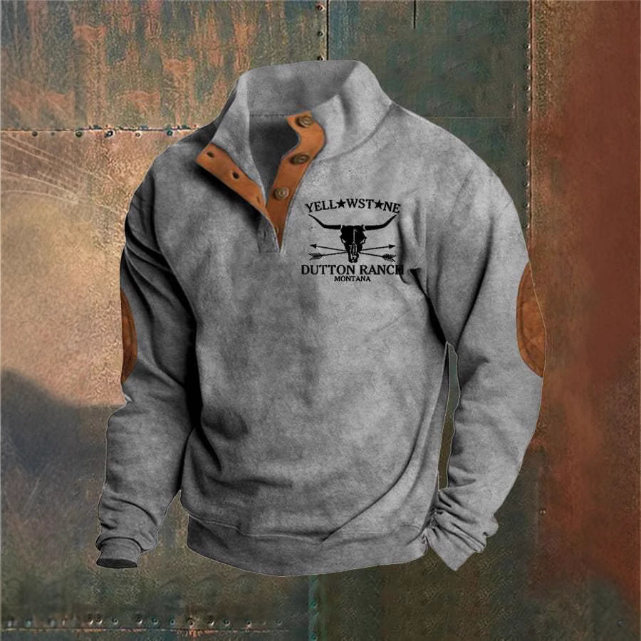 Grå sweatshirt med knapper, læderdetaljer og "Yellowstone Dutton Ranch Montana" tryk. Perfekt til udendørsaktiviteter og casual mode.
