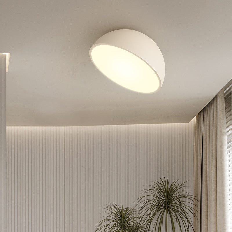 Moderne hvid loftlampe i minimalistisk design, oplyser stilfuldt rum med neutrale farver og indendørs planter. Perfekt til moderne indretning.
