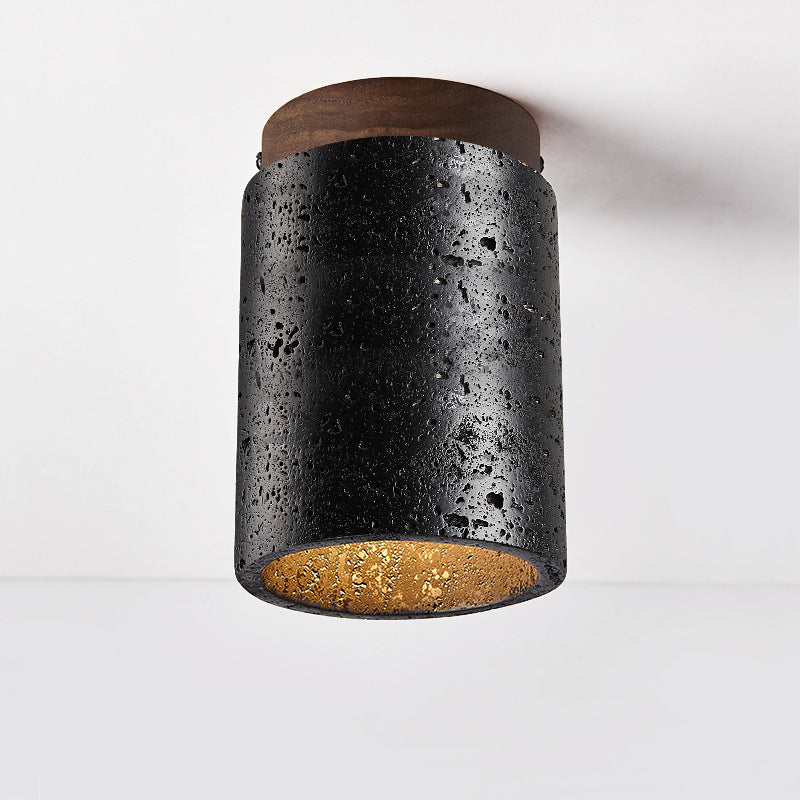 Sort cylinderformet loftlampe i rustikt design med trædetaljer og gylden inderside. Perfekt til moderne indretning og belysning.
