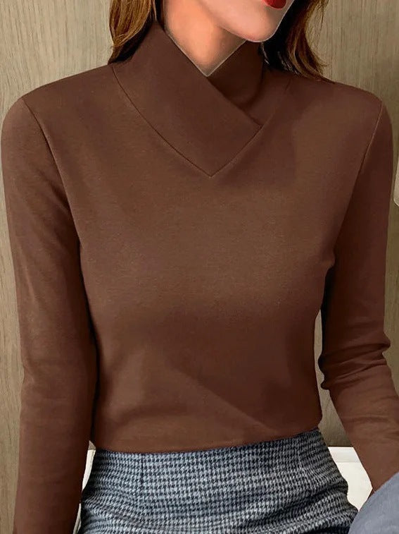 Kvinde iført brun højhalset bluse og gråternet nederdel. Elegant og stilfuldt outfit til efterårsmode.