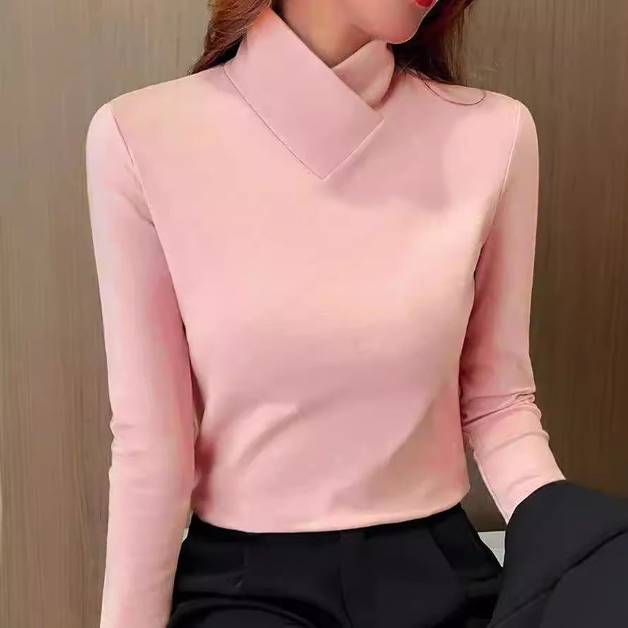 Kvinde iført lyserød højhalset bluse og sorte bukser, moderne tøjstil, minimalistisk design, elegant og stilfuldt look, mode til kvinder.