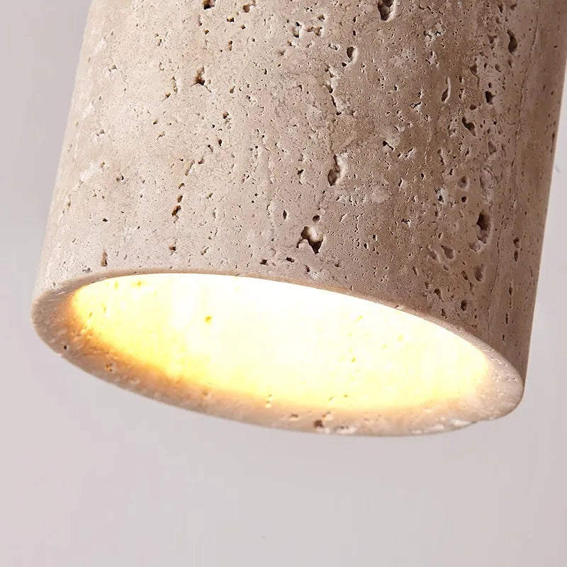 Betonpendellampe med rå overflade, der udsender varmt lys. Moderne belysning, minimalistisk design, ideel til skandinavisk indretning.