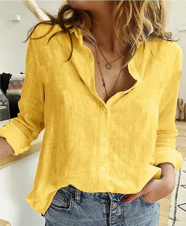 Kvinde iført gul hørskjorte og blå jeans i moderne indretning. Stilfuldt casual outfit, perfekt til forår og sommermode.