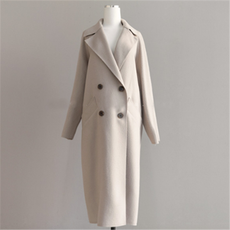 Beige uldfrakke til kvinder på mannequin, dobbeltknappet design, lange ærmer, klassisk stil. Perfekt til vintermode og elegant påklædning.