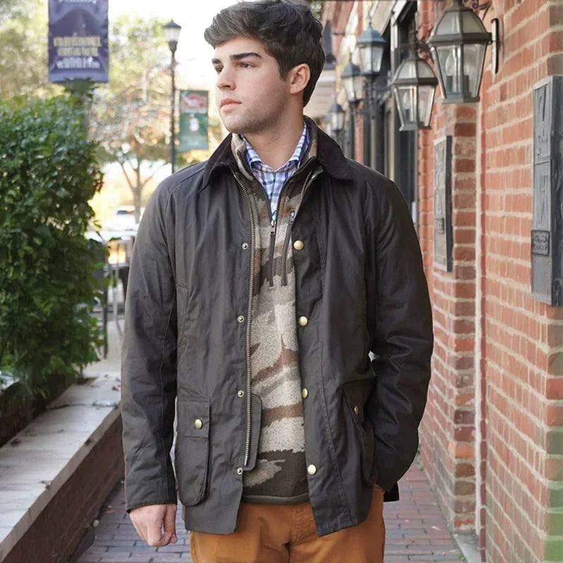 Ung mand iført mørk jakke og ternet skjorte går langs murstensvæg. Mode, herretøj, efterårsjakke, afslappet stil, udendørs.