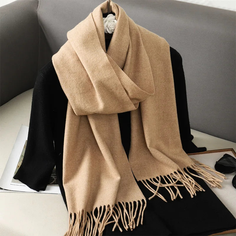 Beige kashmir tørklæde med frynser på sort trøje, elegant og varm til vintermode. Perfekt tilbehør til stilfulde og komfortable outfits.