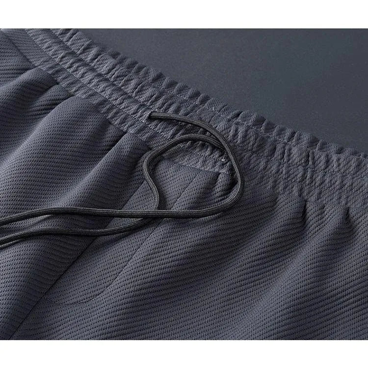 Mørkegrå træningsshorts med elastisk talje og snøre, åndbart stof, ideelle til sport og fitness. Komfortable og stilfulde shorts til mænd.