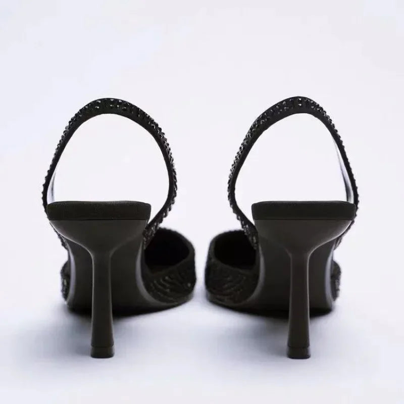 Sorte højhælede sko med stiletter, set bagfra. Elegant design med glitrende detaljer. Perfekt til festlige lejligheder og modebevidste kvinder.