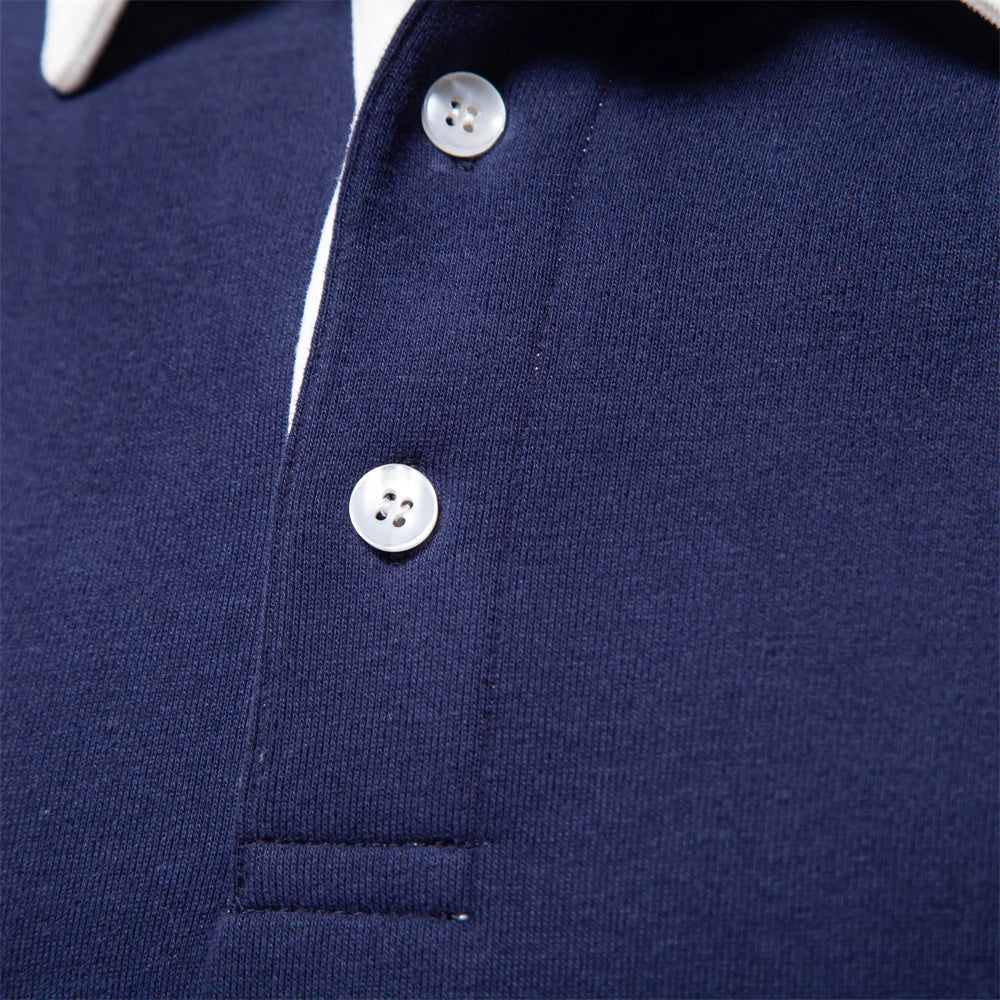 Mørkeblå poloshirt med hvide knapper og krave, tæt på. Klassisk herremode, stilfuldt design, kvalitetsmateriale. Perfekt til casual og formelle lejligheder.