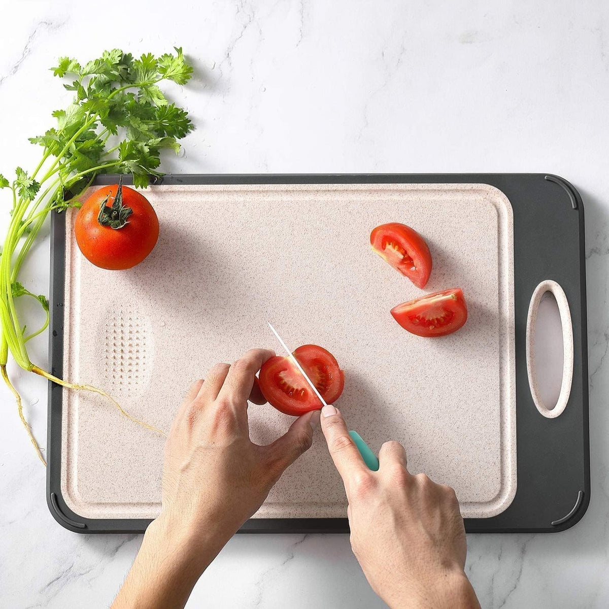 Hænder skærer tomater på en skærebræt med koriander ved siden af. Køkkenredskaber, madlavning, grøntsager, sund madlavning.