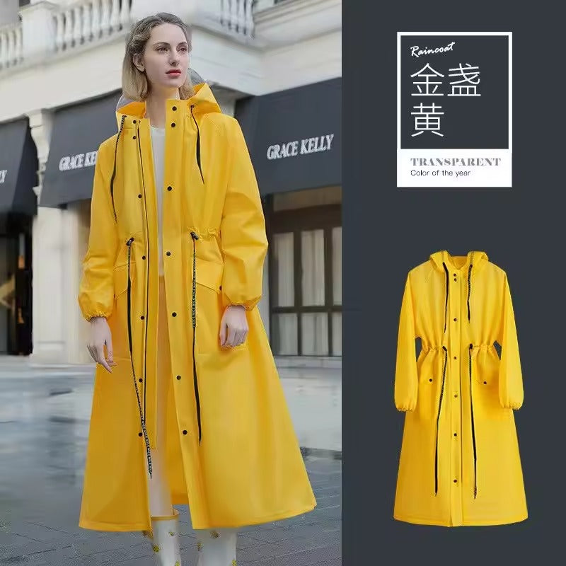 Kvinde iført gul regnfrakke foran butik, moderne design, vandtæt, mode, udendørs beklædning, stilfuld regnjakke, bymiljø, trendy overtøj.