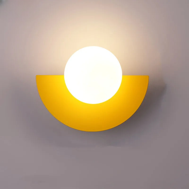 Gul væglampe med halvcirkelformet design og rund, lysende pære. Moderne belysning, stilfuldt interiør, vægdekoration, minimalistisk lampe.