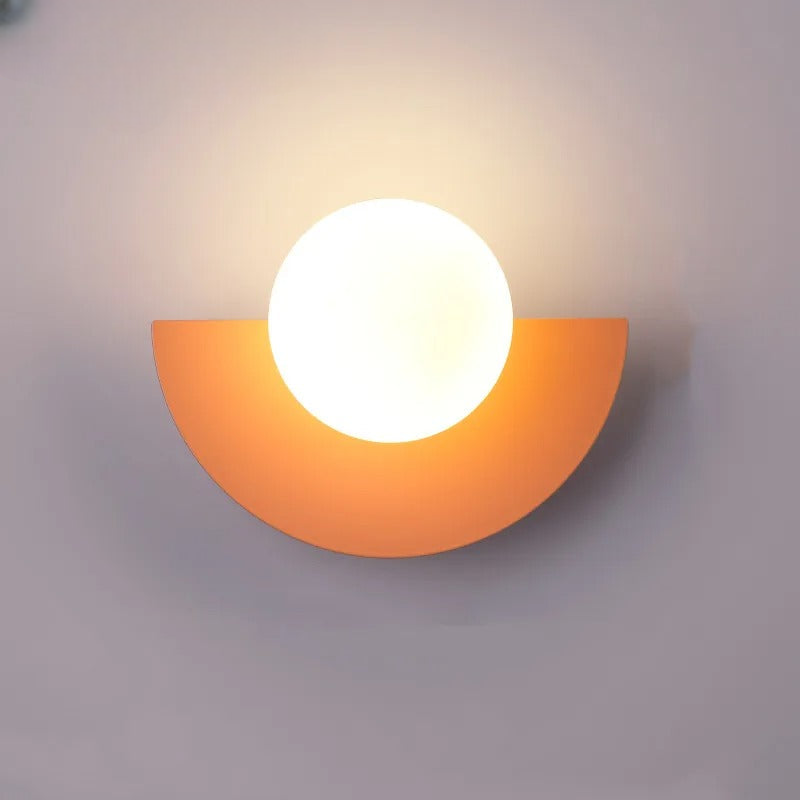 Moderne væglampe med halvcirkelformet orange base og rund hvid skærm. Stilfuld belysning til hjemmet, minimalistisk design, indendørs dekoration.