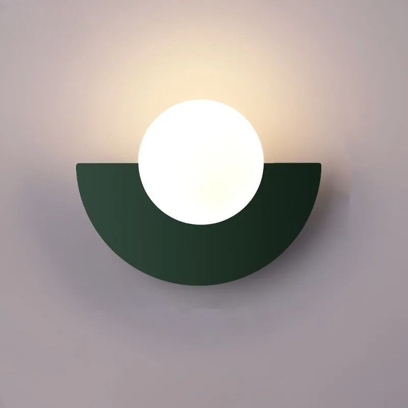 Moderne væglampe med halvcirkelformet sort base og rund hvid lyskilde. Stilfuld belysning til indretning, minimalistisk design.