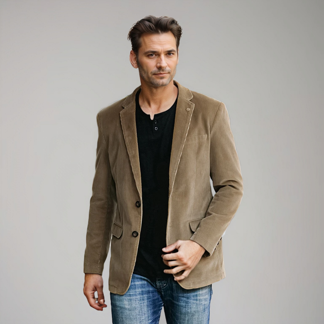 En mand iført en brun fløjlsjakke, sort trøje og blå jeans. Moderne herremode, afslappet stil, stilfuldt tøj til mænd.